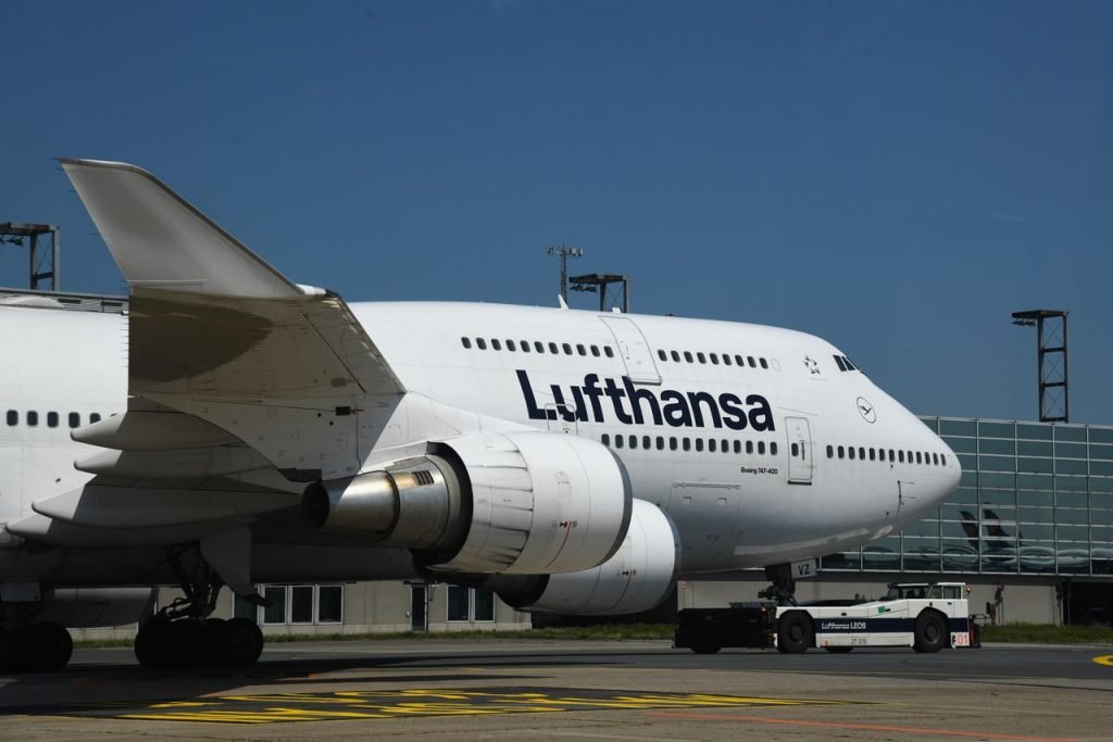 Lufthansa Boeing 747 taxiing at Frankfurt Airport under a clear blue sky.